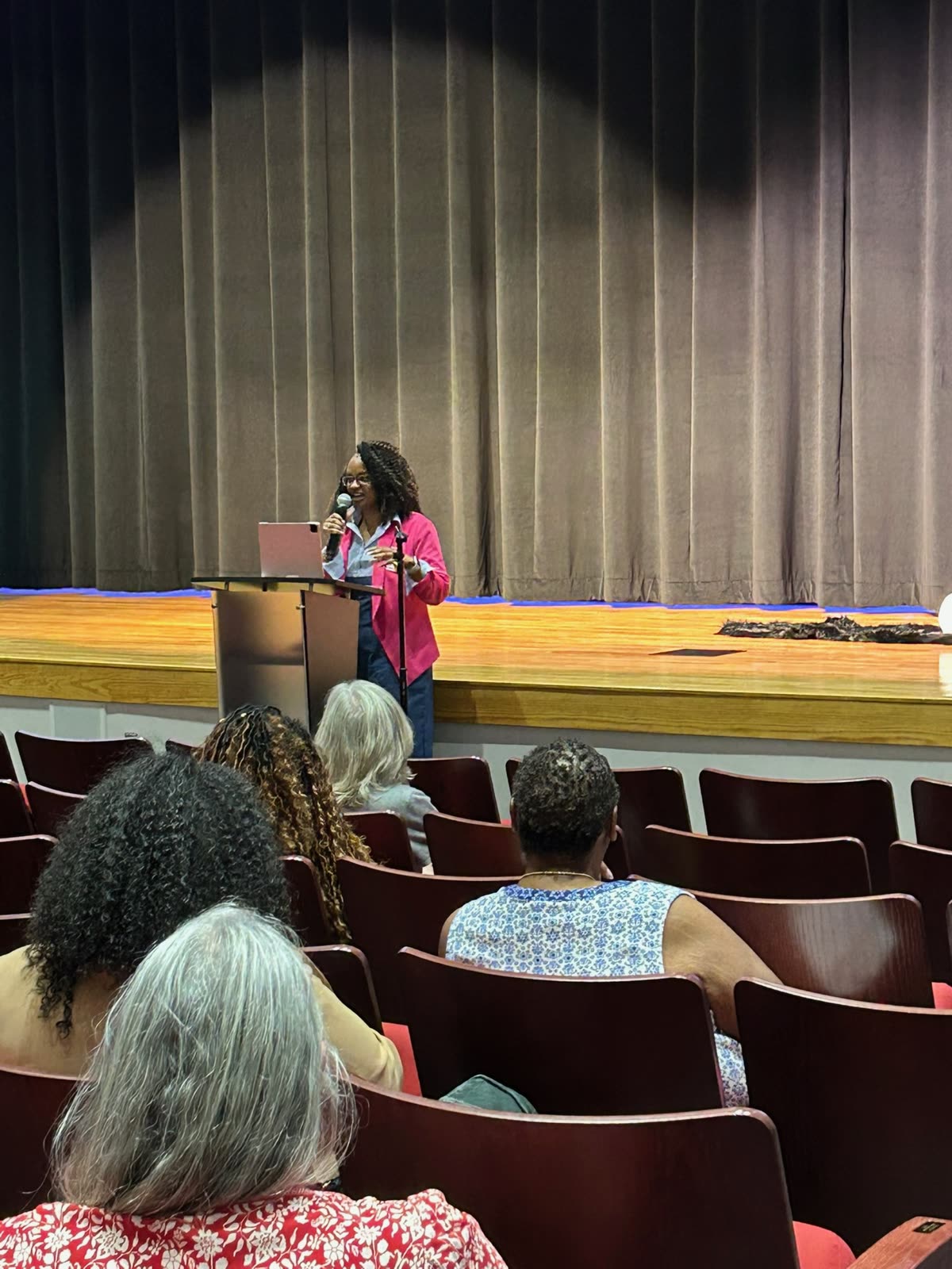 Cara speaking at a podium in an auditorium