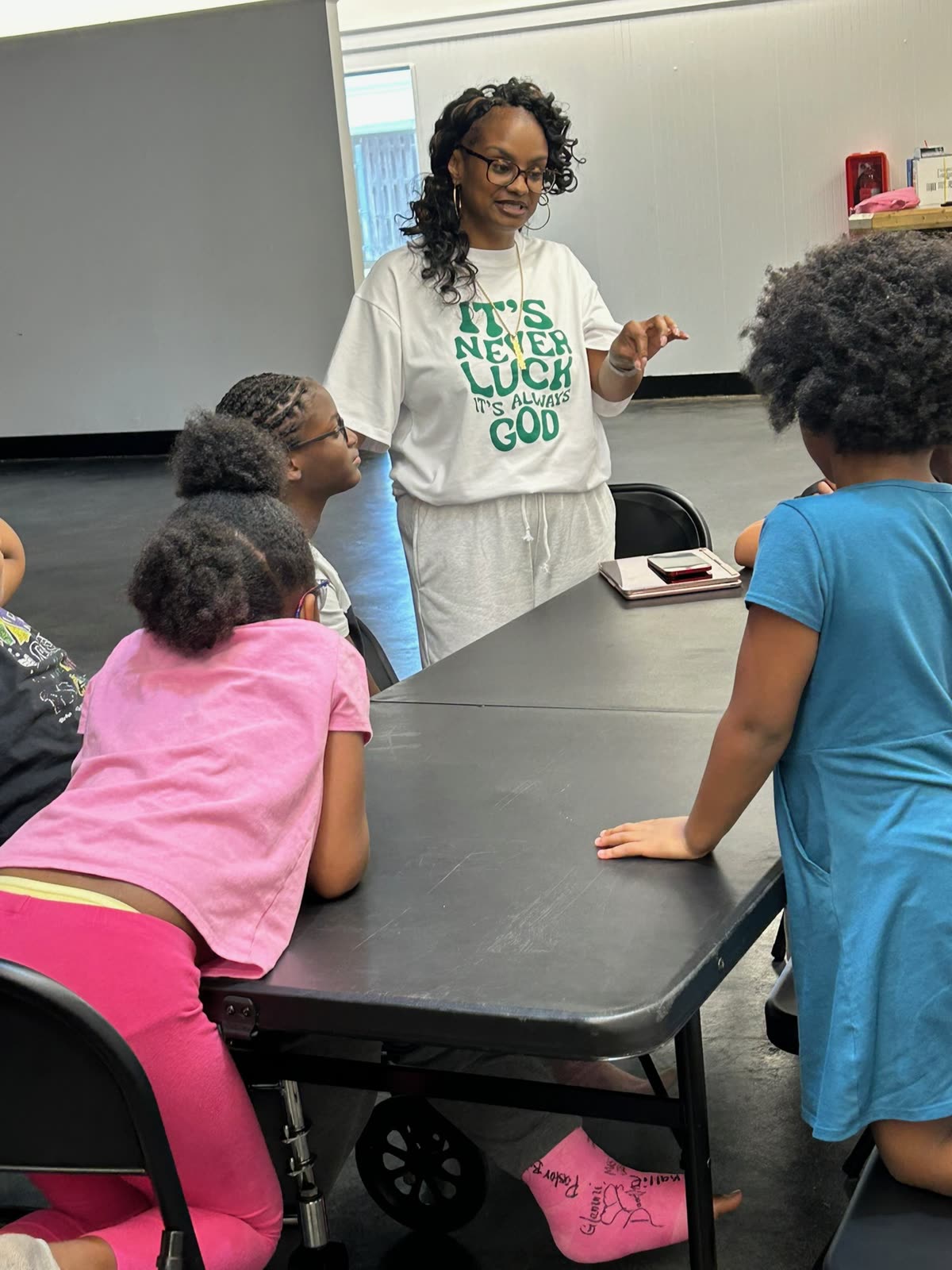 Cara mentoring a group of young girls around a table
